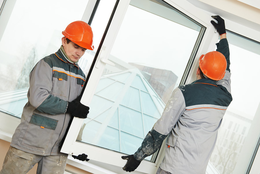 two workers installing the glass window